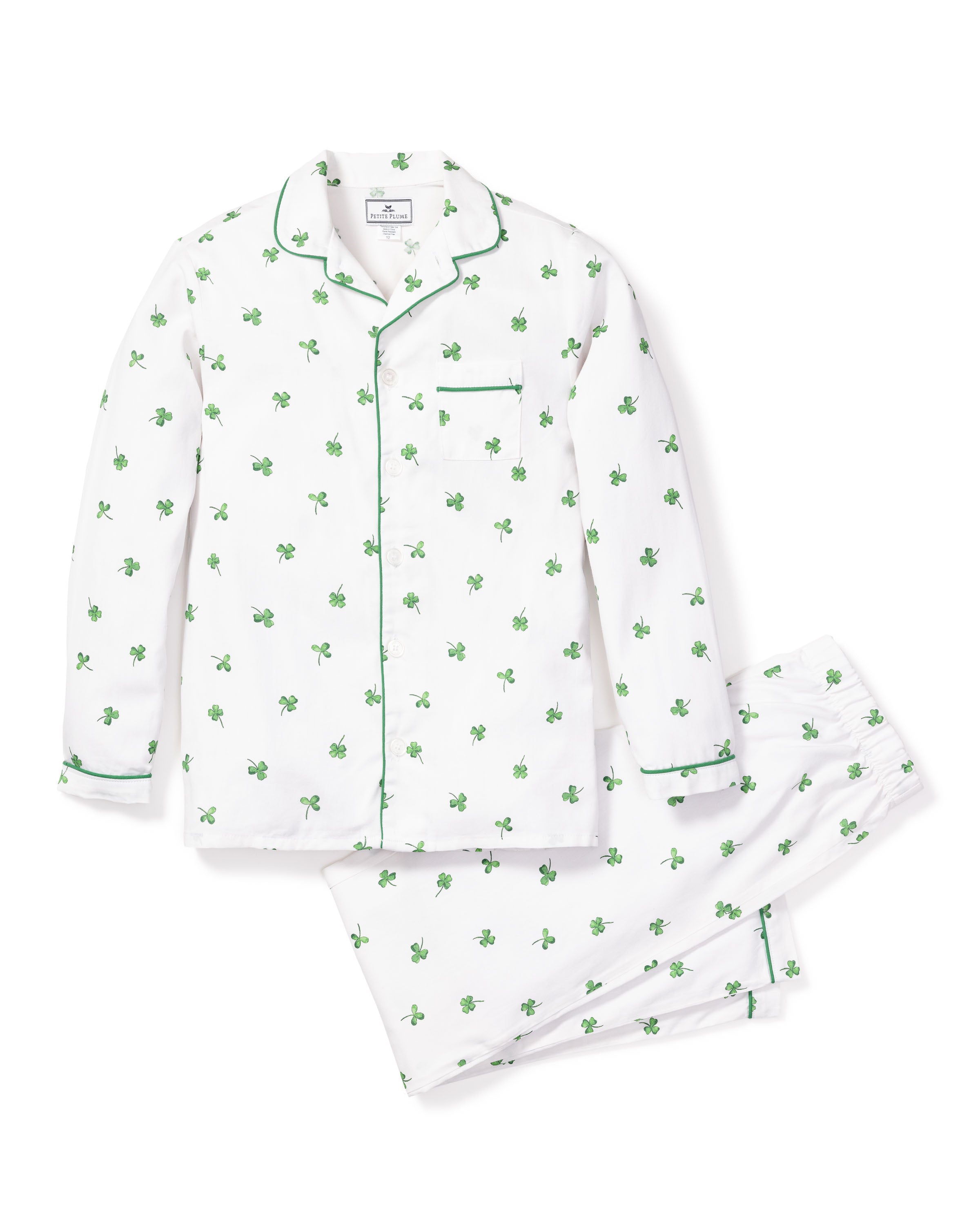 Introducing Petite Plumes Kids Twill Pajama Set in Shamrocks: a luxurious sleepwear collection featuring a white set with green palm tree prints, elegant green piping on the collared long-sleeve top, matching pants, and a stylish chest pocket.