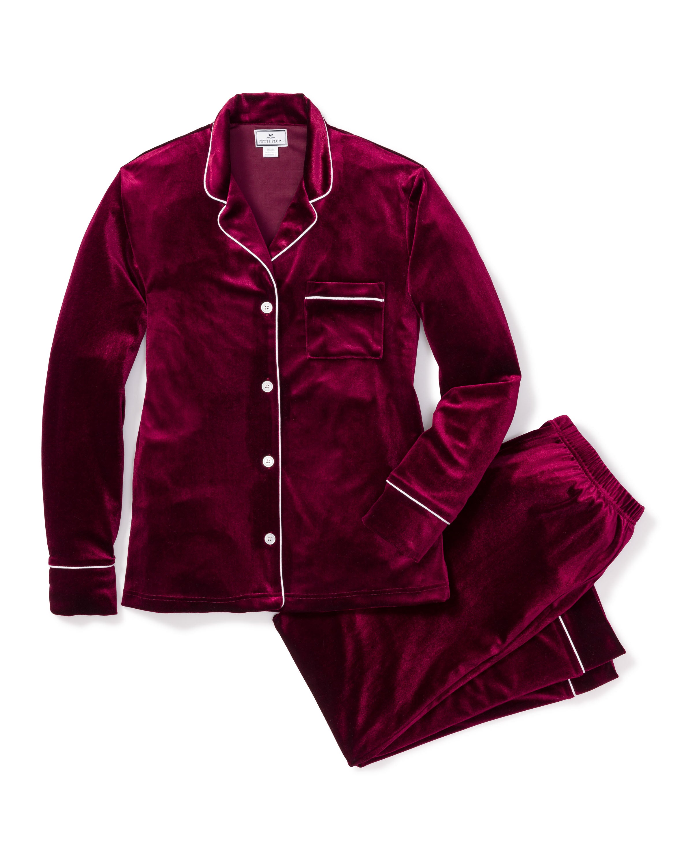 The Womens Velour Pajama Set by Petite Plume in Royal Garnet, featuring white piping, a long-sleeved button-up top with a pocket and matching pants, exudes classic Hollywood style.