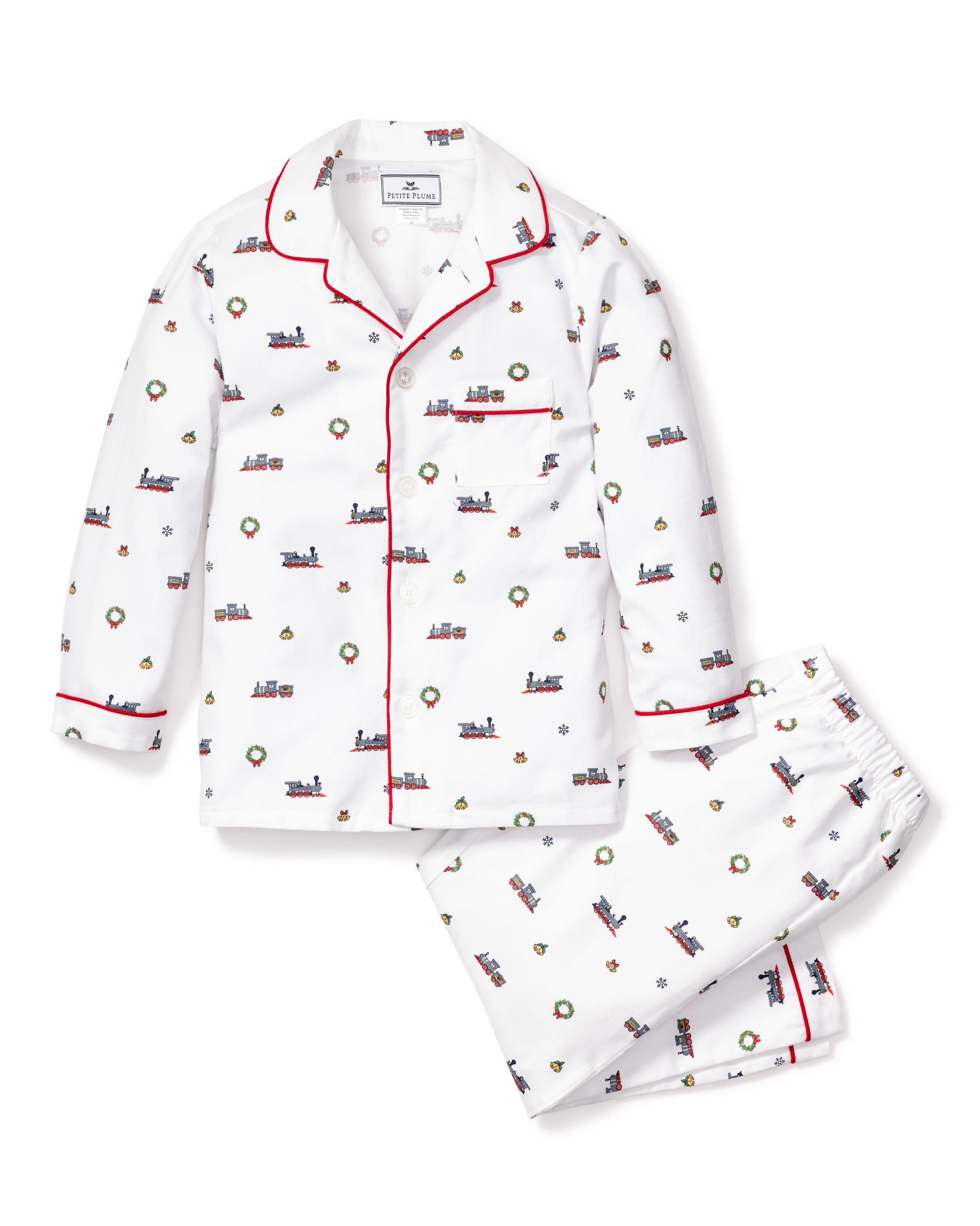 The Kids Twill Pajama Set in Arctic Express by Petite Plume is a cozy twill set featuring white pajamas with colorful train prints and red piping. Made from yarn-dyed cotton, it includes a long-sleeve button-up top with a pocket and matching pants adorned with small trains and Christmas wreaths.