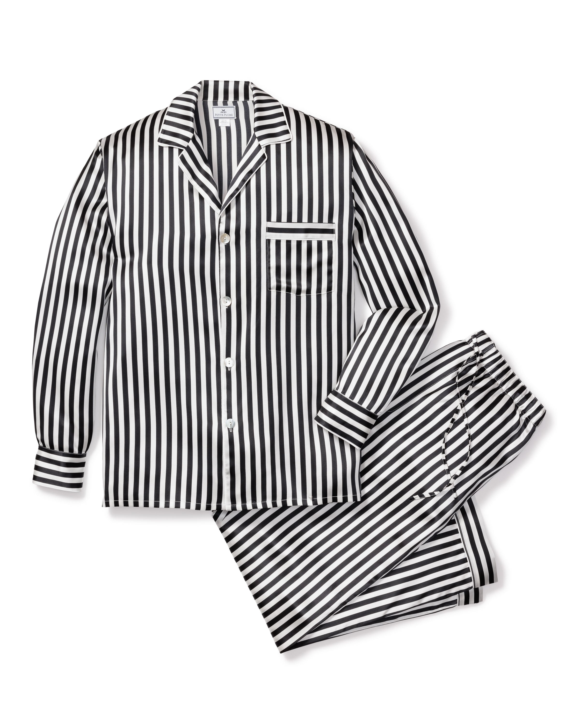 The Mens Silk Pajama Set in Bengal Stripe by Petite Plume boasts a luxurious black and white design crafted from premium Mulberry silk, featuring a long-sleeved button-up top with a chest pocket and matching pants, all elegantly arranged on a white background.