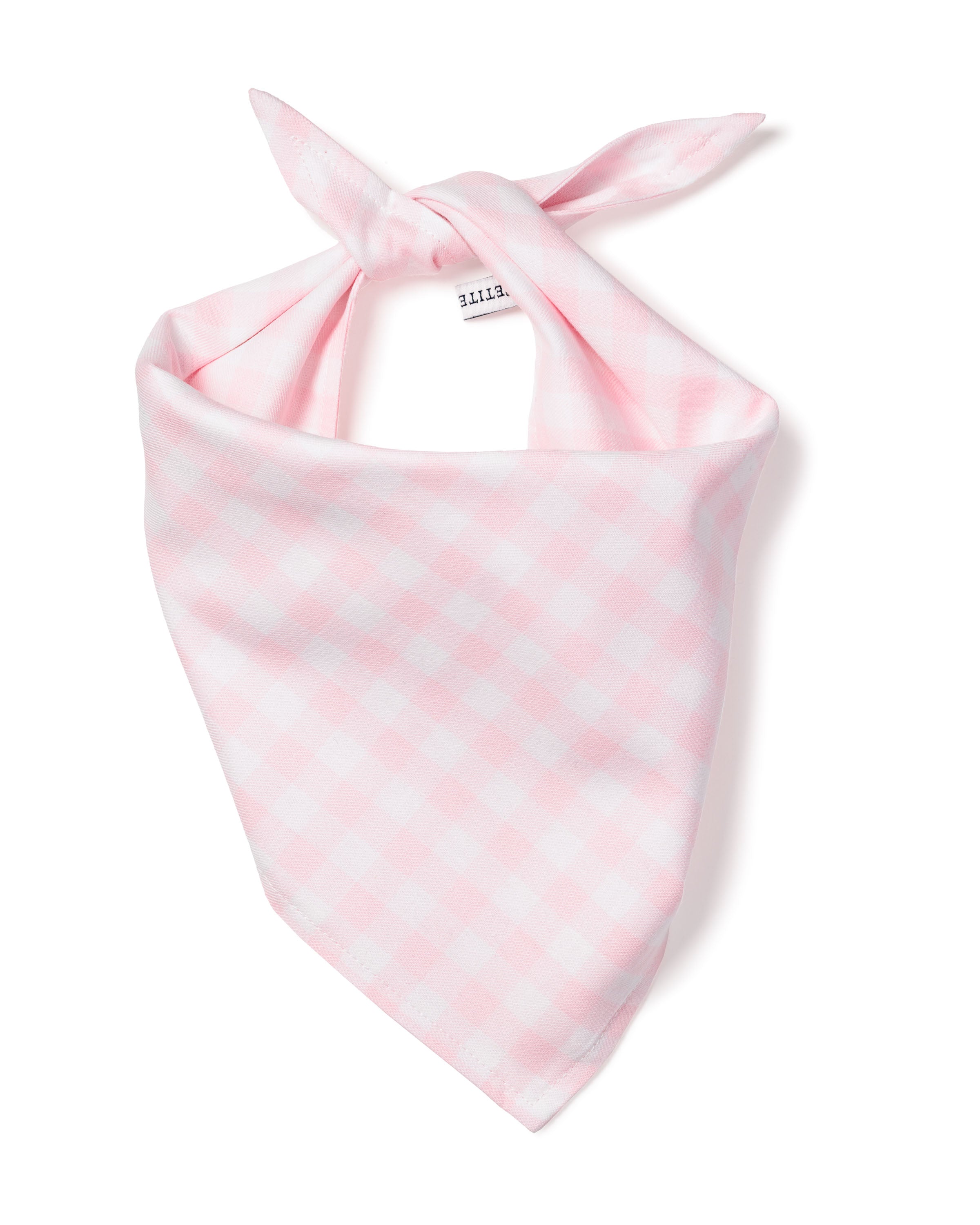 The Petite Plume Dog Twill Bandana in Pink Gingham is a charming dog accessory with a triangular shape and knot at the top. Made from soft, lightweight fabric, it features a small white tag with text.