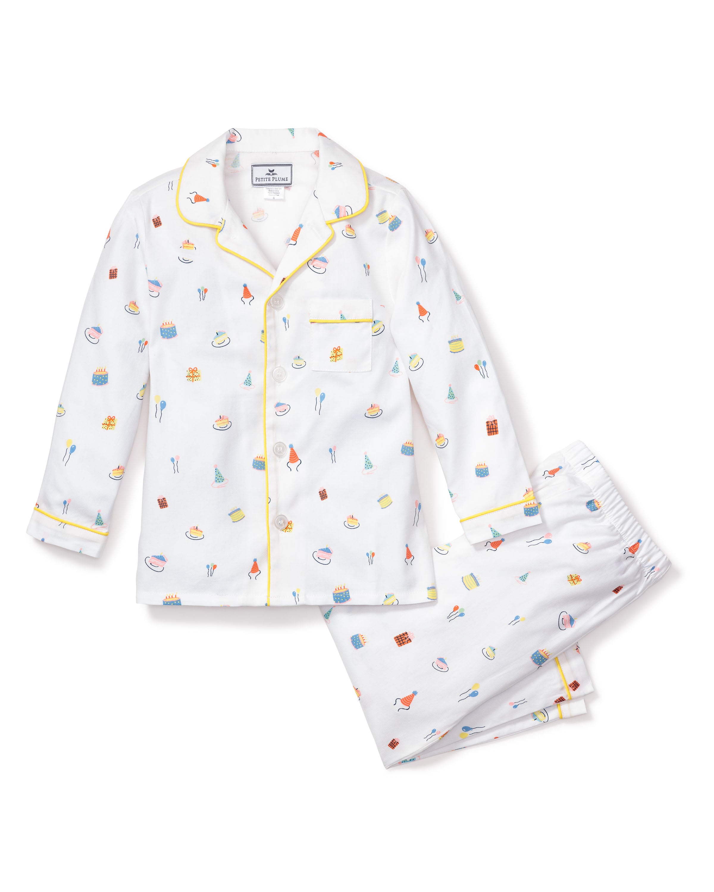 The Kids Twill Pajama Set in Birthday Wishes by Petite Plume is adorned with prints of small kitchen items like whisks, eggs, and pastries. This comfy classic set includes a top with a pocket and yellow piping, perfect for cozy relaxation.