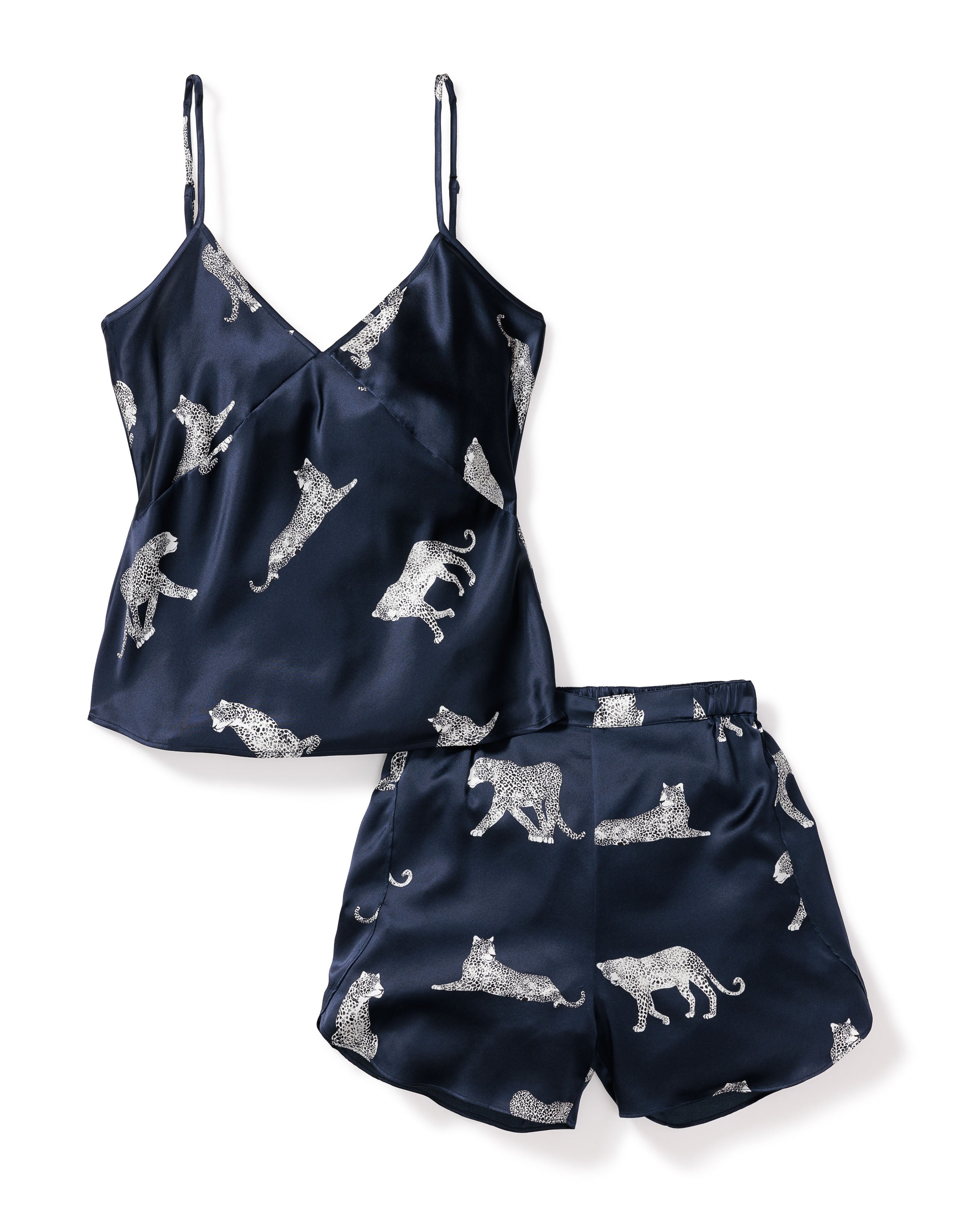 The Womens Silk Cami Short Set in Panthère de Nuit by Petite Plume is a luxurious navy blue Mulberry silk pajama set featuring a spaghetti strap top and shorts. It showcases an elegant pattern of white leopards, capturing the essence of the Panthère de Nuit design.