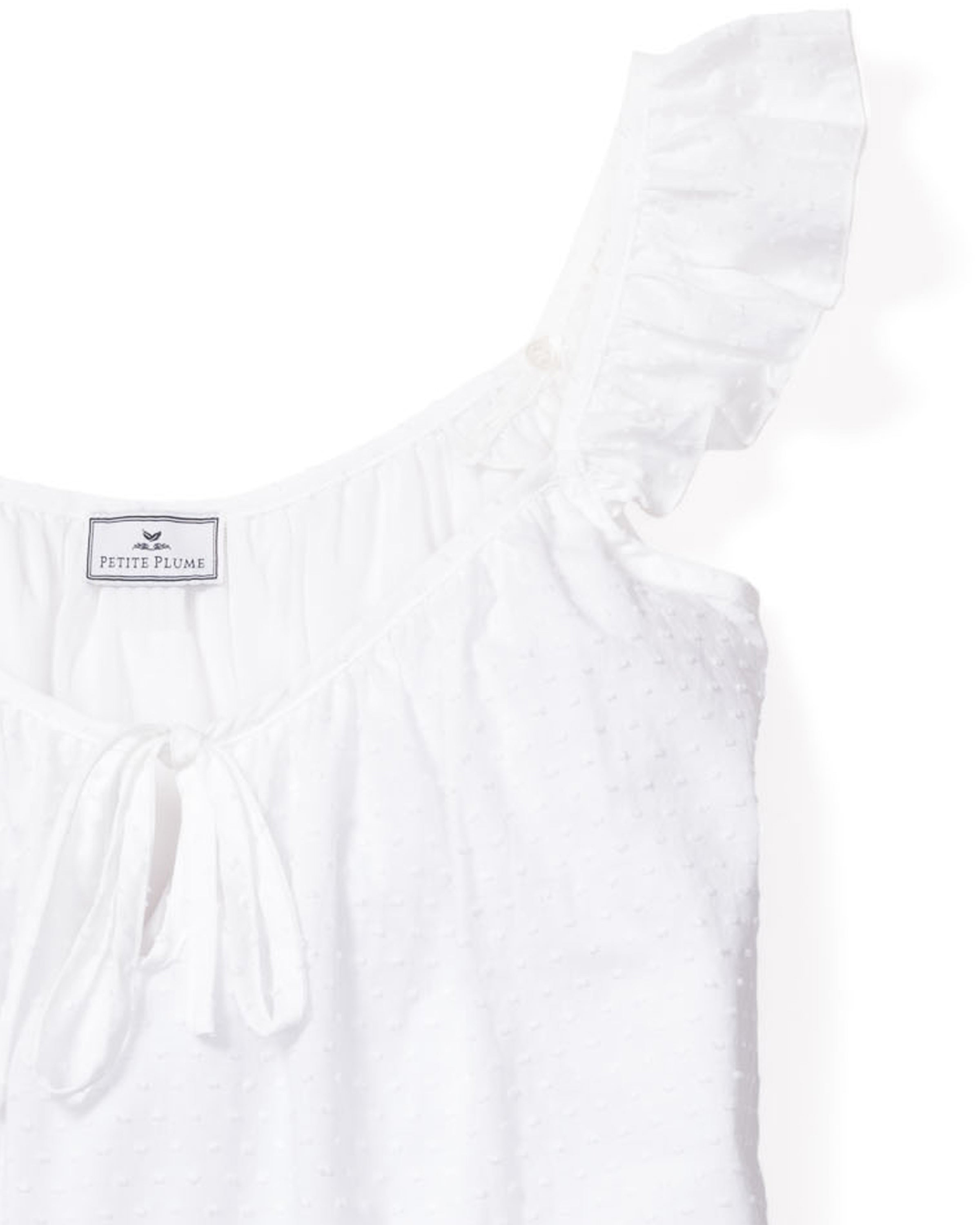 The Womens Swiss Dots Celeste Short Set in White by Petite Plume features a white sleeveless top with a tie-front, ruffled shoulder strap, and is made from soft cotton swiss dot fabric for a subtle dotted texture.