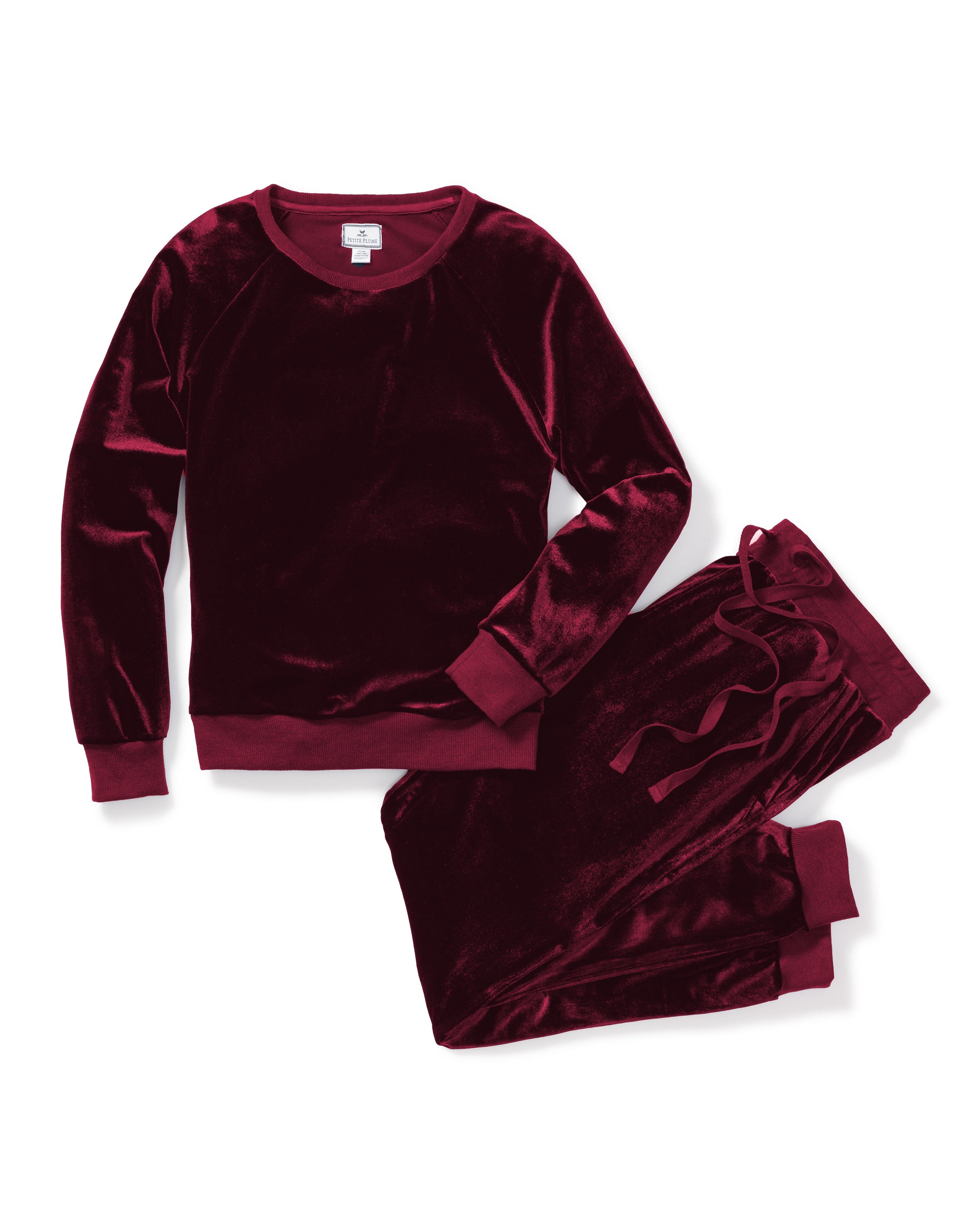 Part of Petite Plumes Cabaret Collection, the Womens Velour Lounge Set in Royal Garnet includes a long-sleeve top and matching drawstring pants. Its fabrics soft sheen enhances its luxurious Hollywood-style look, set against a white background.