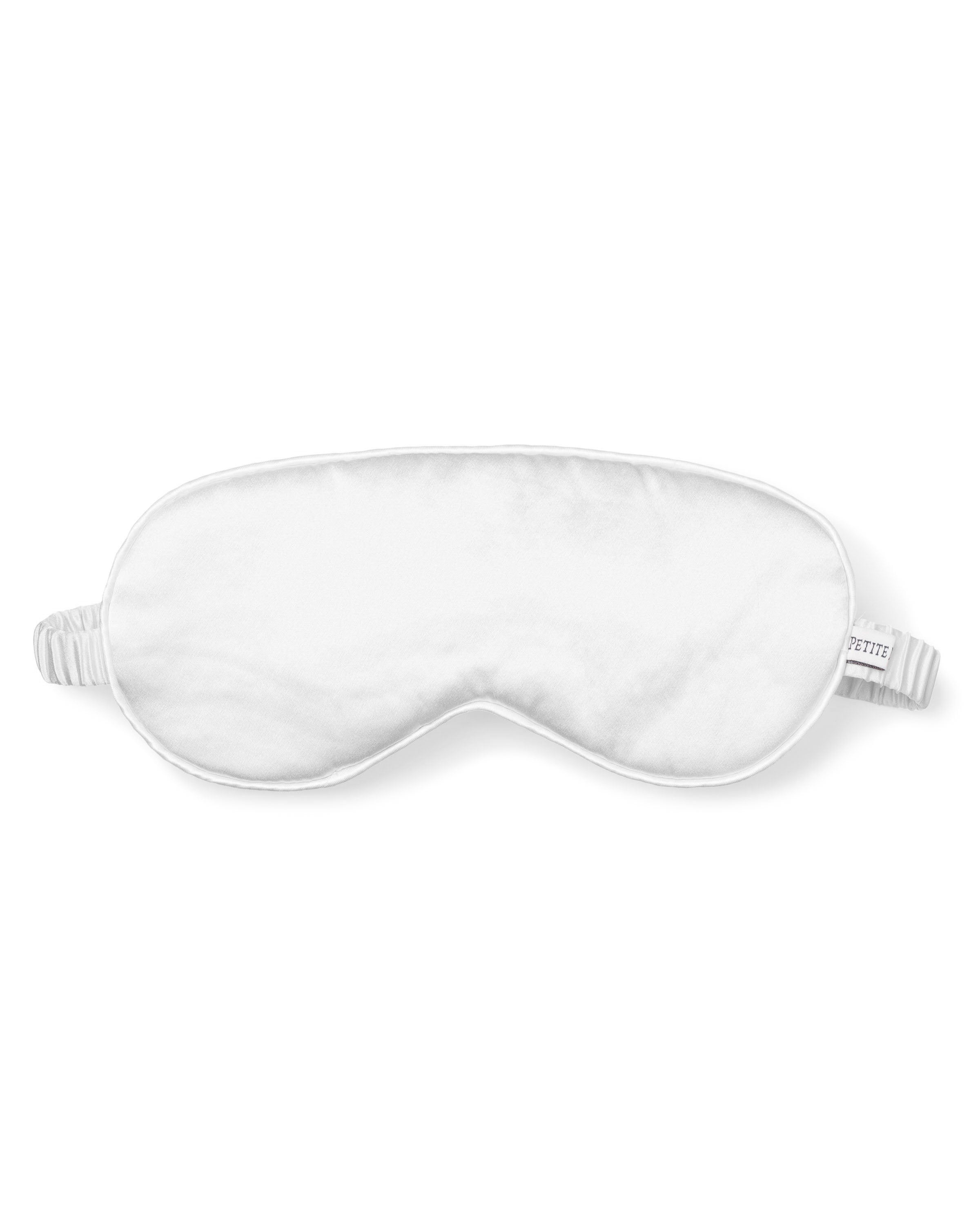 The Womens Silk Sleep Mask in White by Petite Plume, featuring a comfortable elastic band for full eye coverage, is showcased against a plain white background.